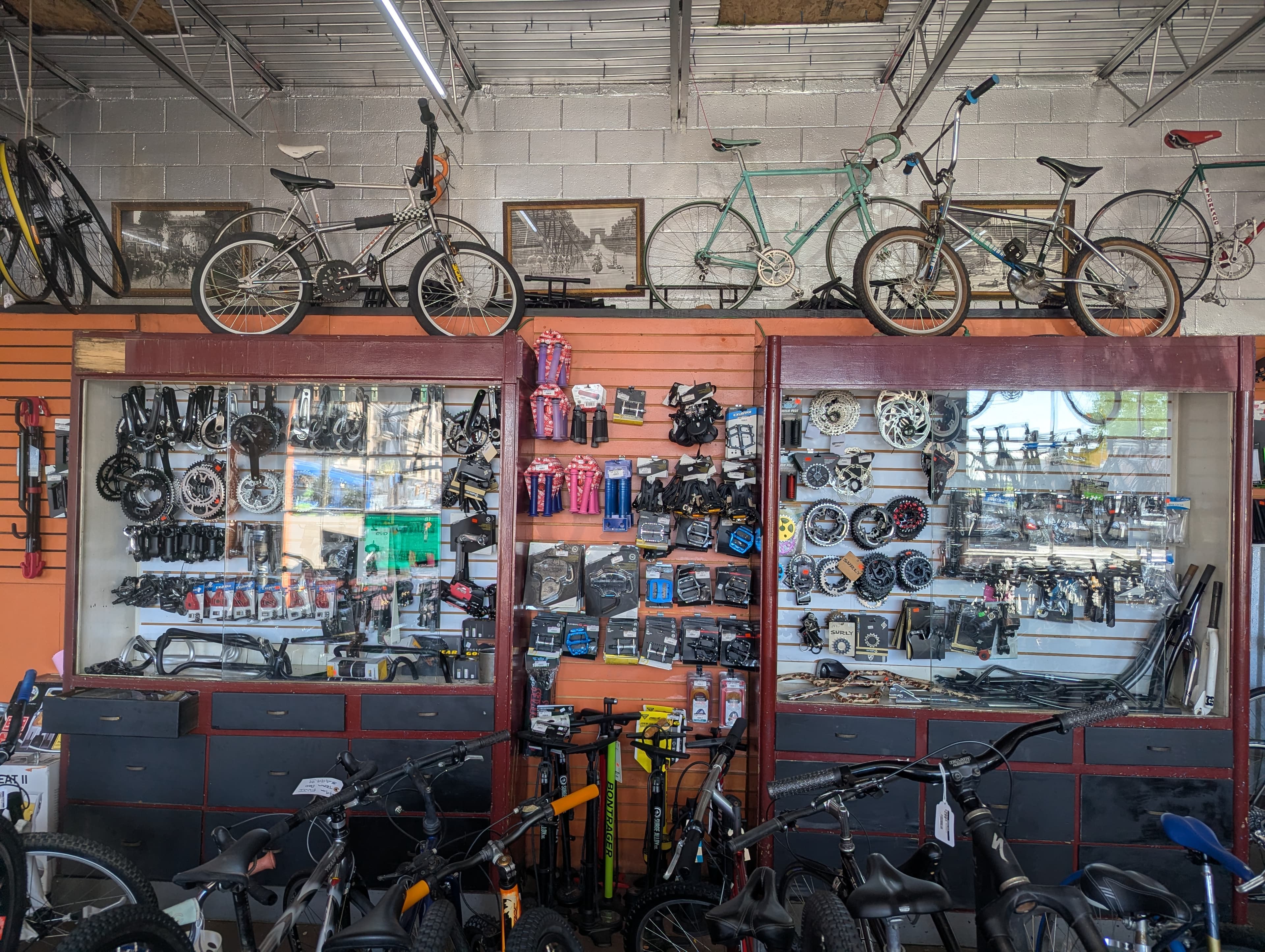 Hearns Cycling parts display cases with cranksets, brakes, and accessories