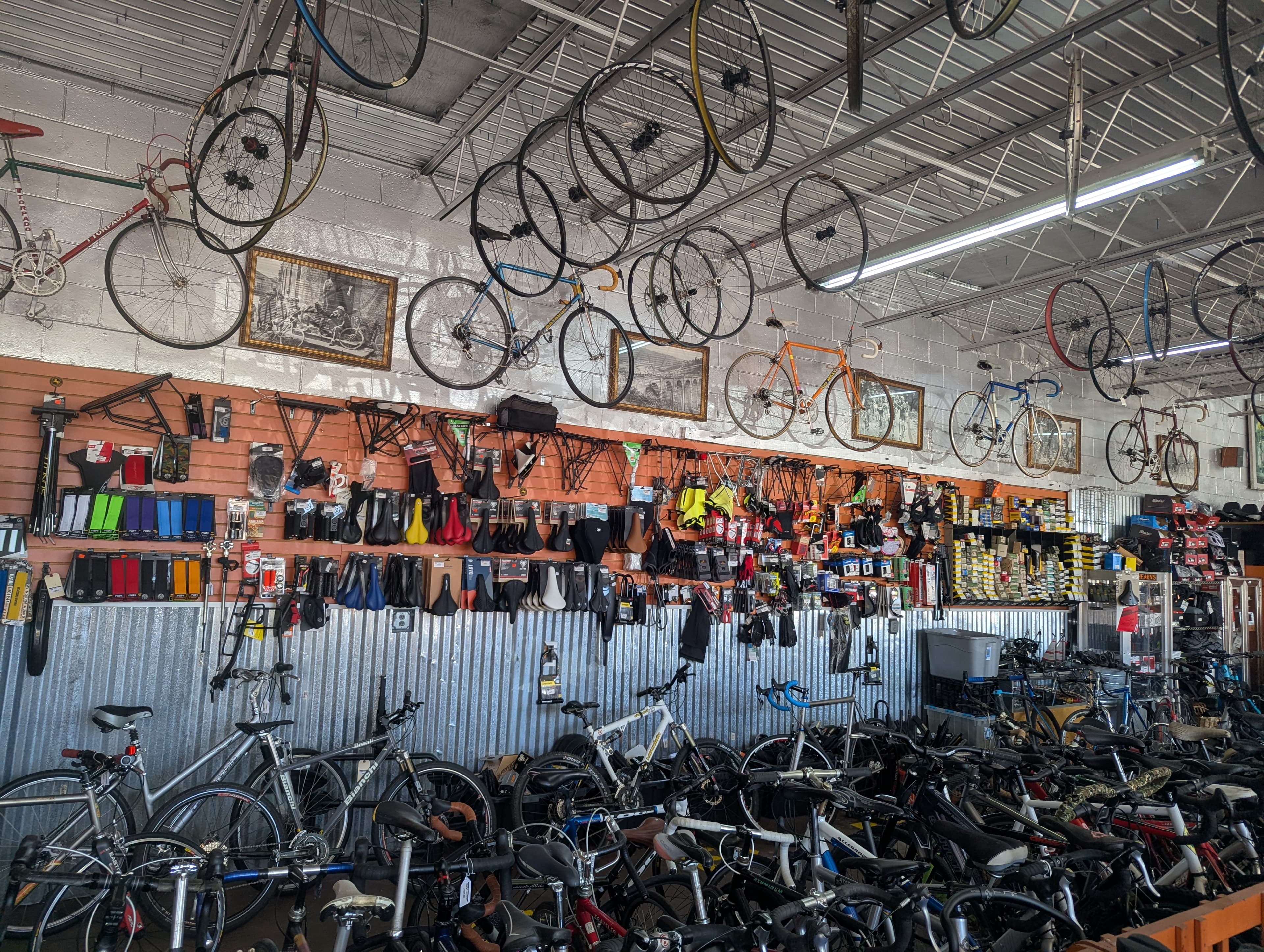 Hearns Cycling shop interior showing saddles, seatposts, and accessories wall
